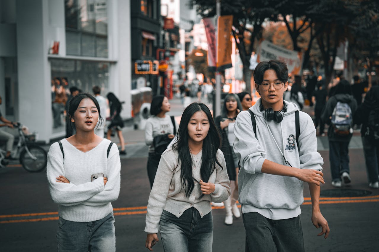 Group of young friends strolling through a lively street in Seoul, showcasing urban youth culture.